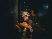 Ein Feuerwehrmann steht vor einem Gebäude. Inder Hand hält er ein Tableau zur Atemschutzüberwachung. Im Hintergrund ist das Logo der Firma Vetter an einer Hallenfassade erkennbar.