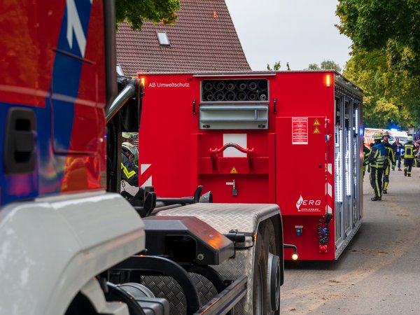 Ein Wechselladerfahrzeug der Feuerwehr Friedrichshafen hat den Abrollbehälter Umweltschutz auf einer Straße abgeladen.
