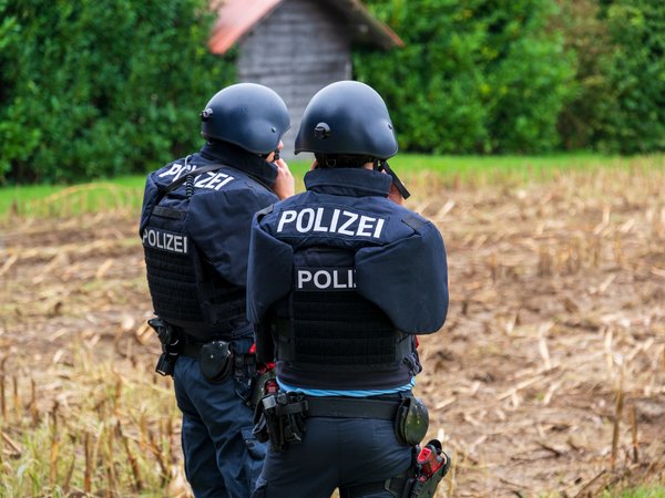 Zwei Kräfte der Polizei in ballstischen Westen und Schutzhelmen.