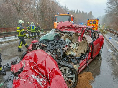 Das zerstörte Unfallfahrzeug, im Hintergrund ein Rettungswagen und der Rüstwagen der Feuerwehr Tettnang.
